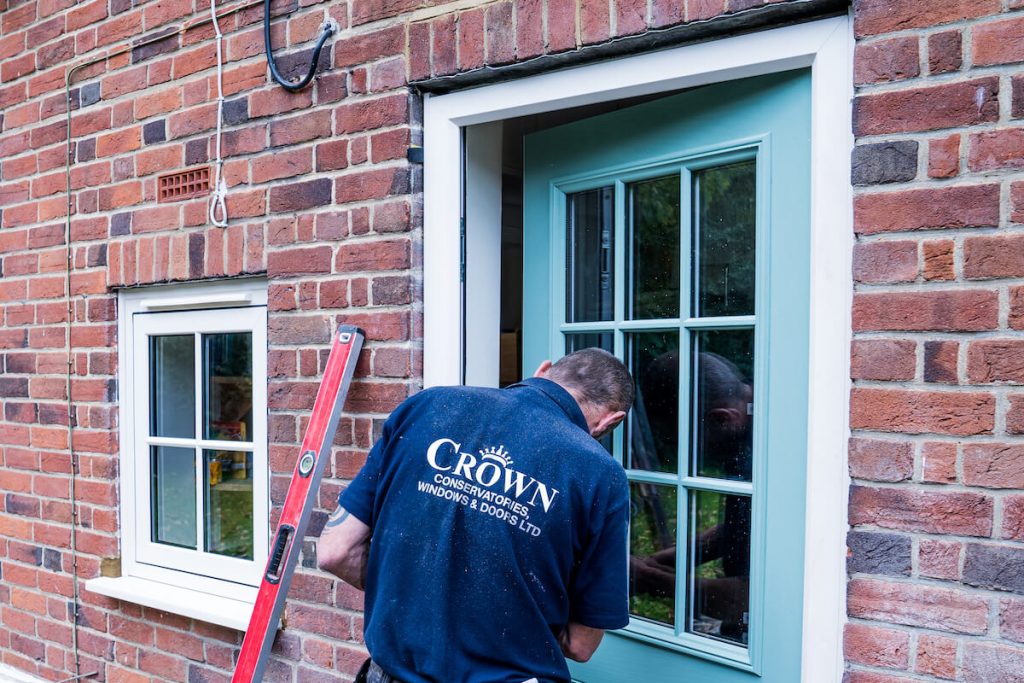 crown worker installing front door