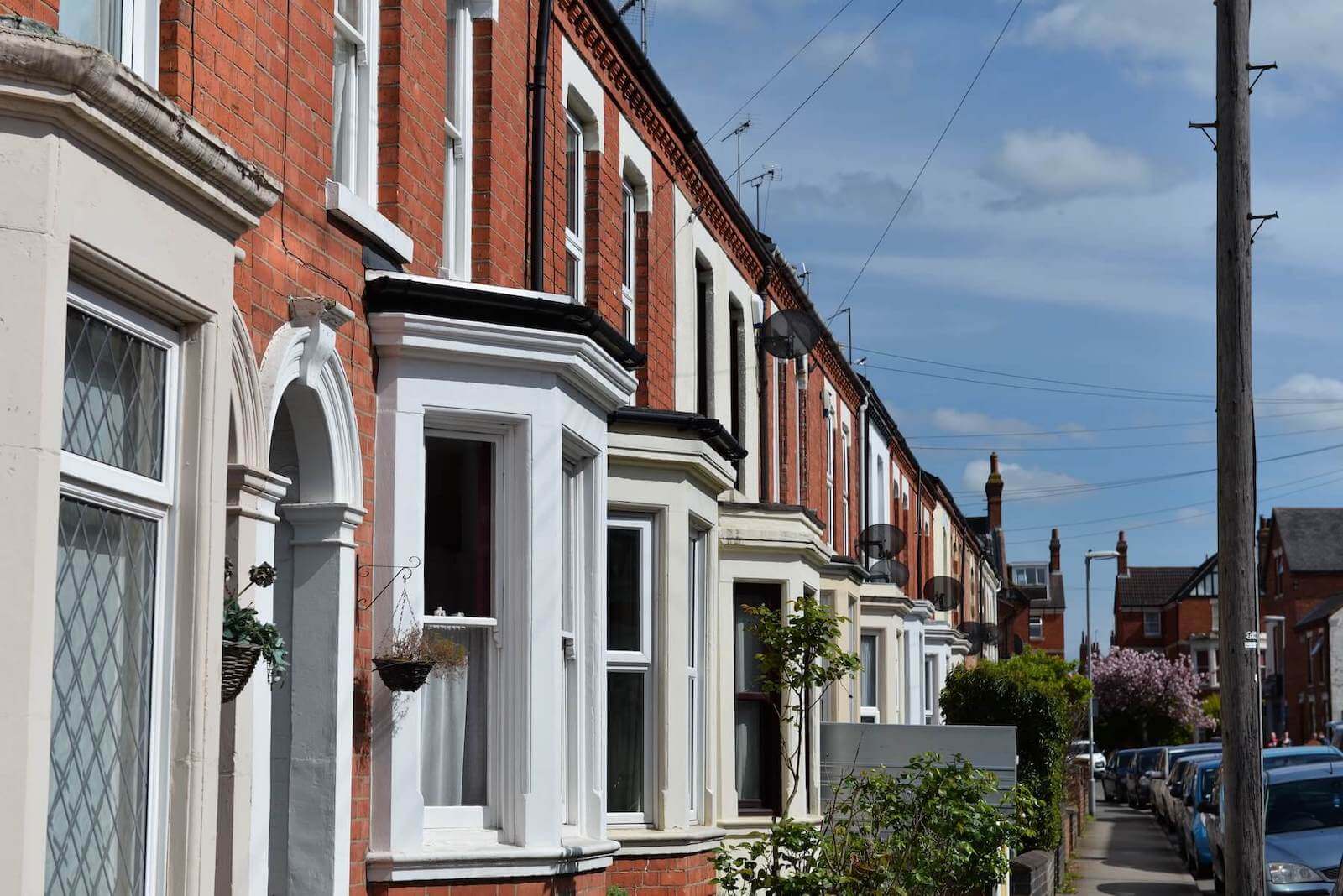 Row of traditional British terraced houses with double glazed windows in Northampton on a sunny day.